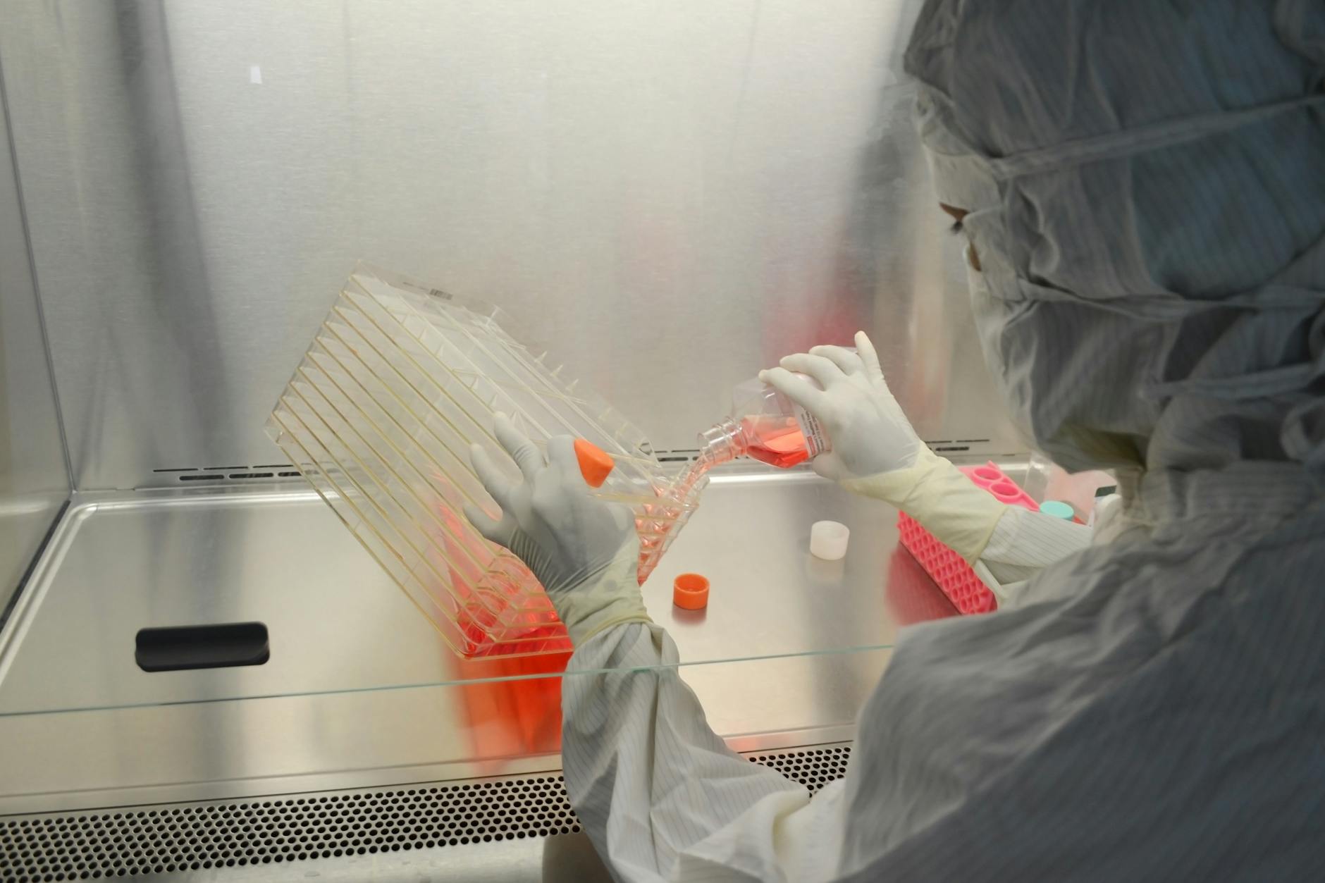 Cientista com equipamento de proteção completo trabalhando em laboratório de pesquisa genômica