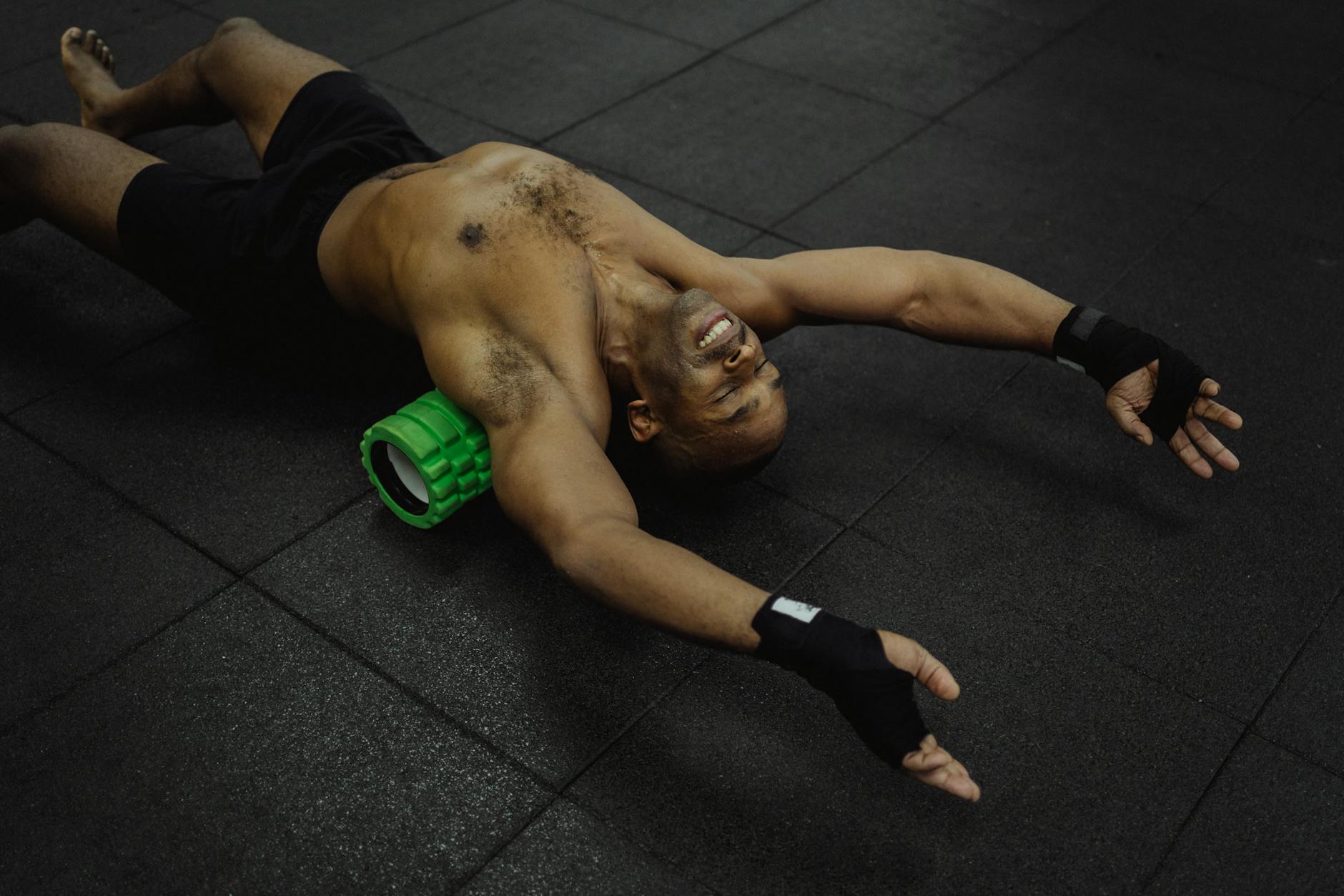 Homem usando rolo de espuma nas costas em um centro de fitness para recuperação muscular