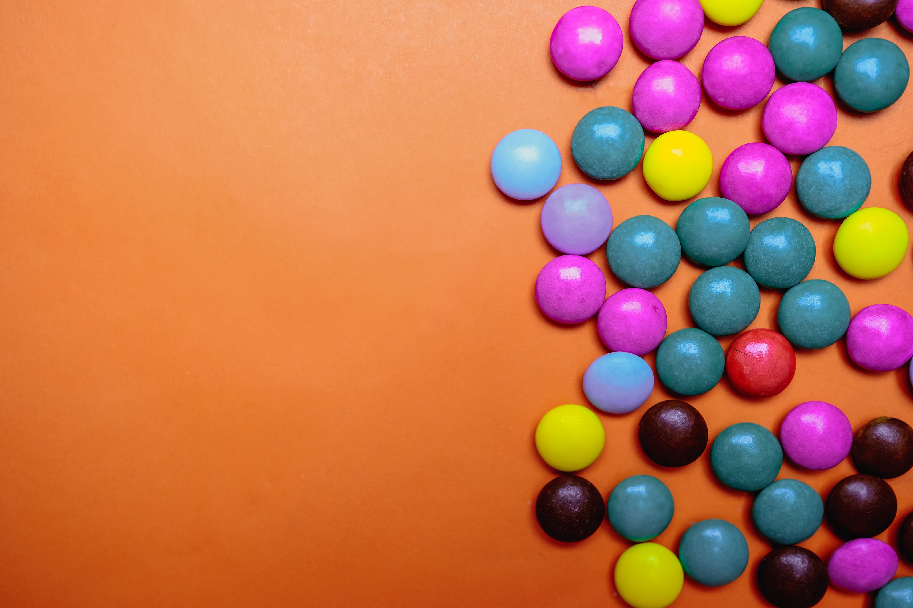 Diversos doces e balas coloridas espalhados, representando a variedade de alimentos açucarados