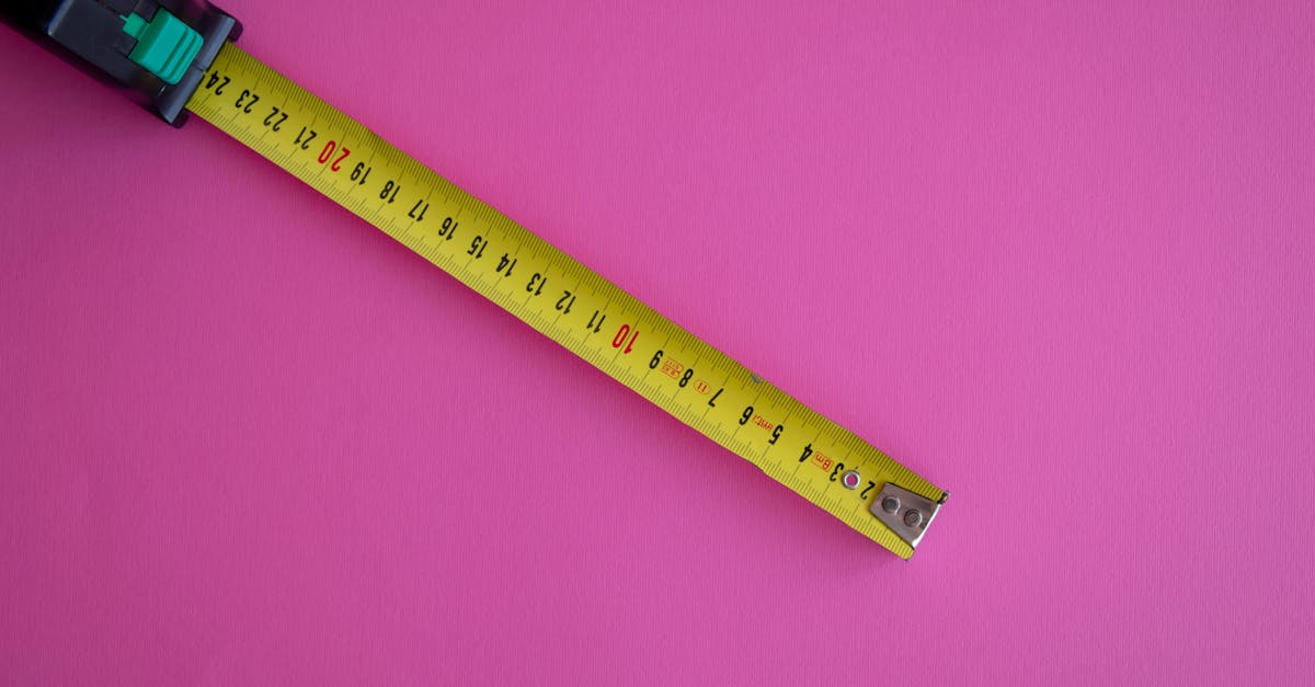 Fita métrica amarela estendida sobre fundo rosa, representando a medição da altura humana