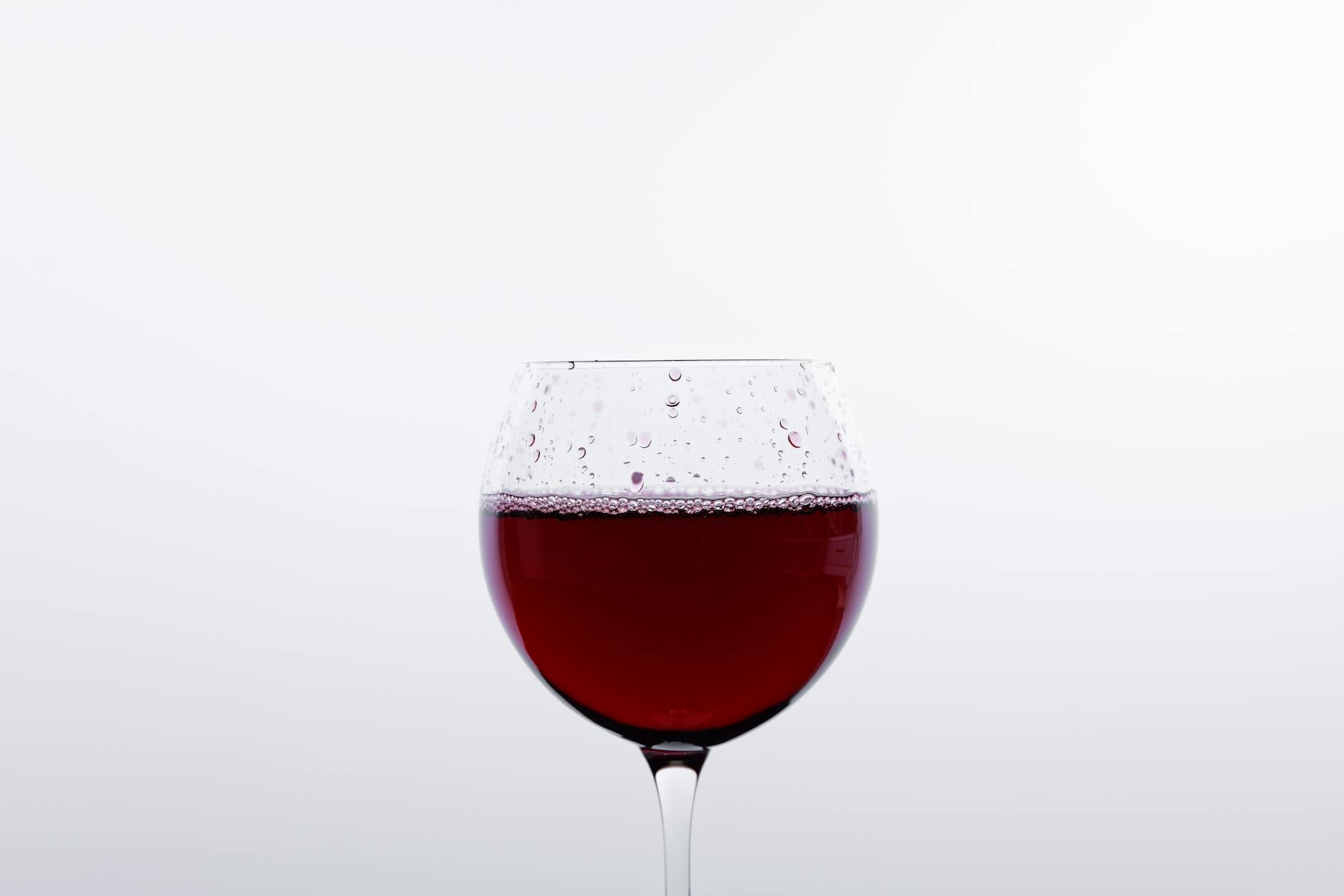 Taça de vinho tinto sendo servida, um dos principais gatilhos da intolerância à histamina