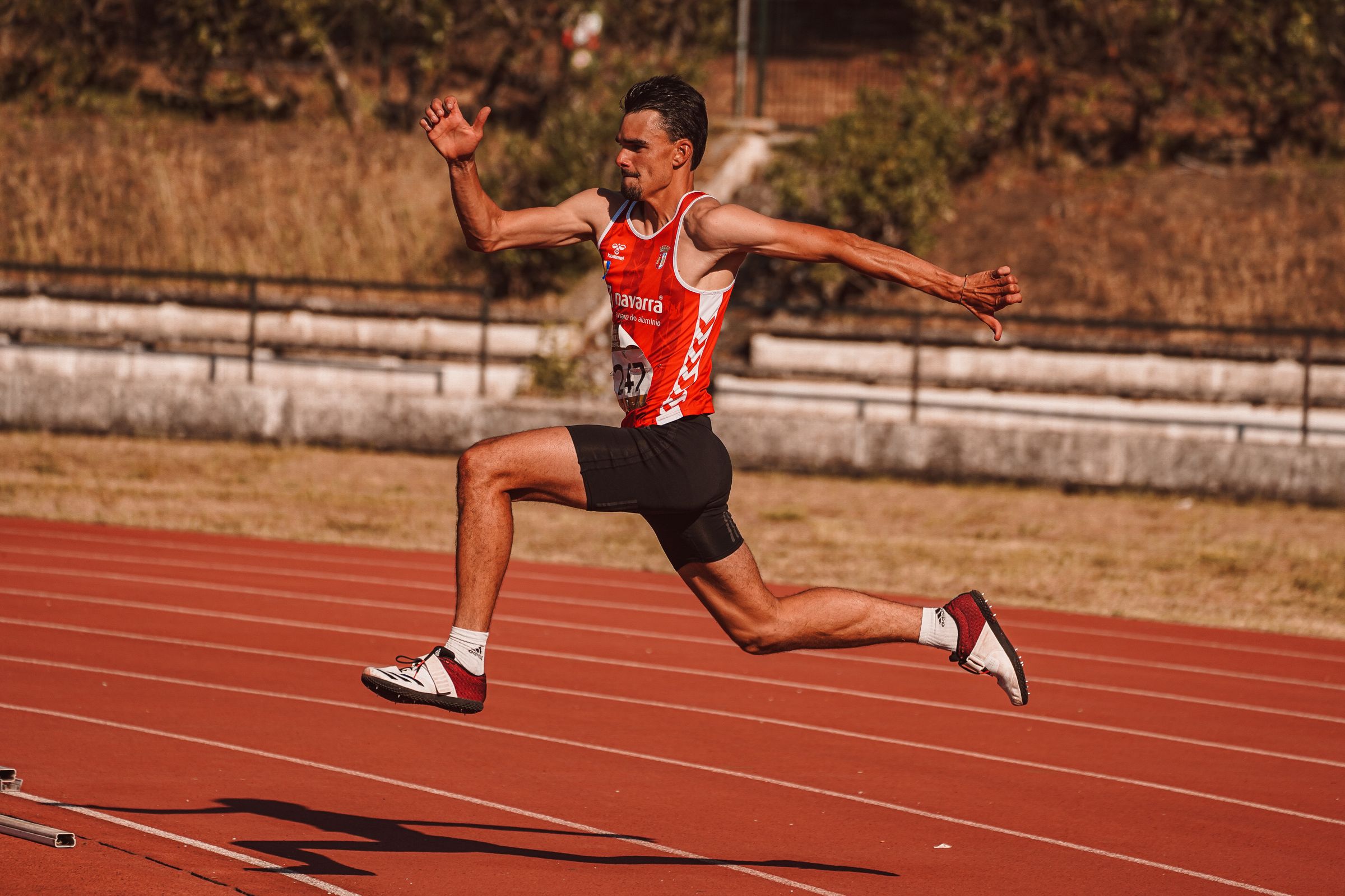 Atleta correndo em alta velocidade em uma pista de estádio