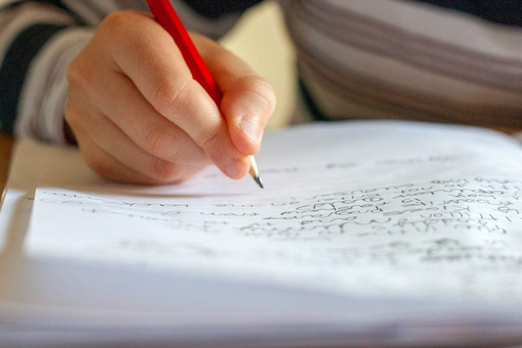 person writing on white paper